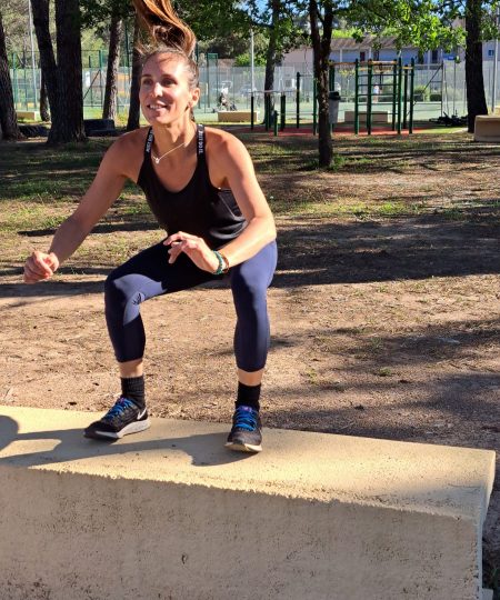 Femme en train de réaliser un box jump lors d'une séance de sport en plein air